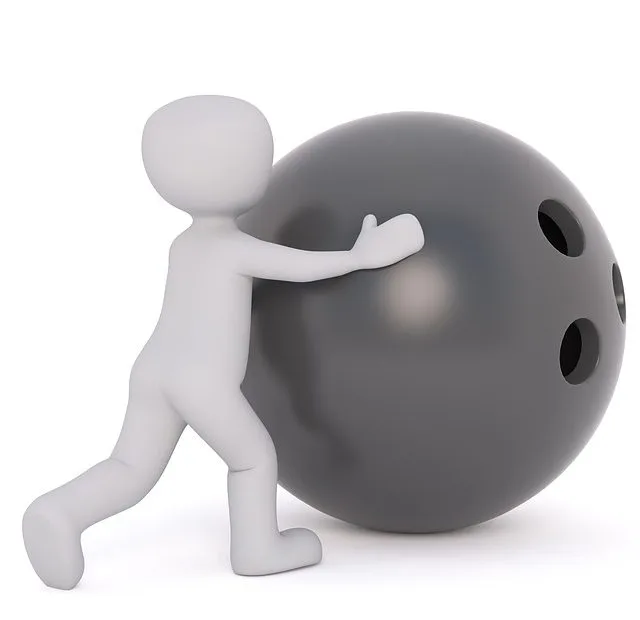 Litet barn knuffar ett enormt bowlingklot