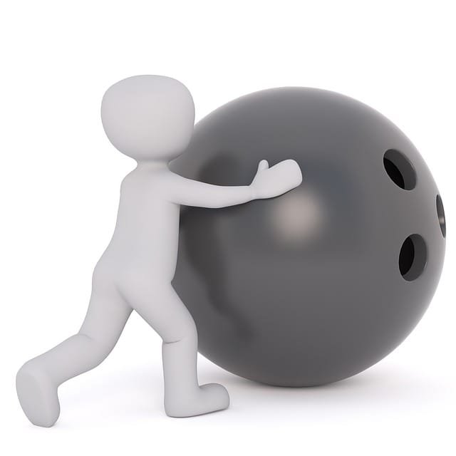 Litet barn knuffar ett enormt bowlingklot